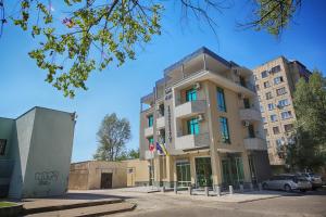un edificio alto con macchine parcheggiate di fronte di Continental Hotel a Kutaisi