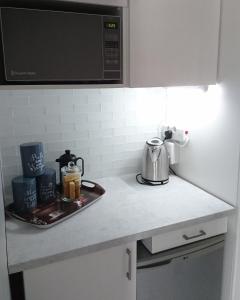a kitchen counter with a coffee pot on a tray at Hamilton Garden Suites in Parklands