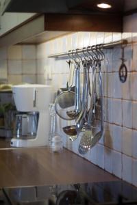 a kitchen counter with utensils hanging on a wall at Villa Blue Island in Artemida