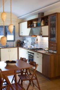 Una cocina con una mesa de madera y una mesa y sillas. en Villa Blue Island, en Artemida