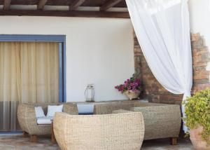 a patio with wicker chairs and a table at Villa Blue Island in Artemida