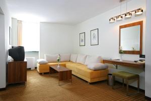 - un salon avec un canapé et une télévision dans l'établissement Hotel Laguna Zagreb, à Zagreb