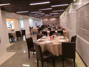 un comedor grande con una mesa larga con sillas en Hotel San Antonio, en Ávila