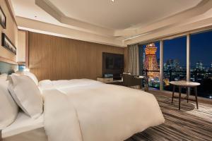 a bedroom with a large white bed and a city skyline at The Prince Park Tower Tokyo - Preferred Hotels & Resorts, LVX Collection in Tokyo