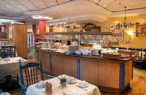 a restaurant with a counter with food on it at Country Hotel Timmendorfer Strand in Timmendorfer Strand