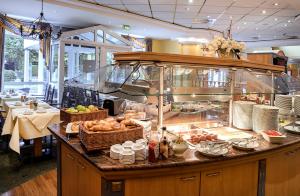a buffet in a restaurant with food on a counter at Country Hotel Timmendorfer Strand in Timmendorfer Strand