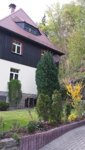 ein weißes Haus mit rotem Dach in der Unterkunft Ferienwohnung Am Elbradweg in Bad Schandau