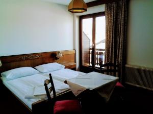 ein Schlafzimmer mit einem Bett und einem Fenster mit Aussicht in der Unterkunft Mosers Pension in Villach
