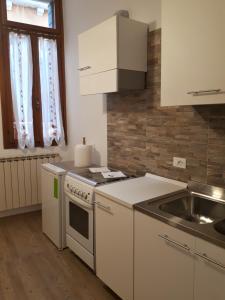 a kitchen with white cabinets and a sink and a stove at Ca' del Megio in Venice