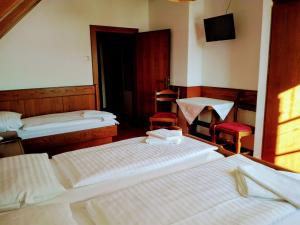 a room with three beds and a table and chairs at Mosers Pension in Villach