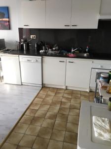 a kitchen with white cabinets and a tiled floor at Apartment Zaventem Brussels Airport G in Zaventem