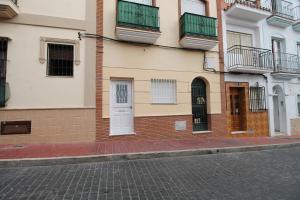 ネルハにあるCasa San Juan SpainSunRentals 1088の白い扉のある通りの建物