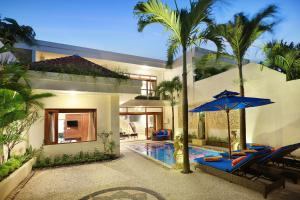 a villa with a swimming pool and a house at Villa Mawar Legian in Legian
