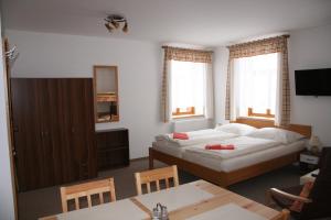 ein Wohnzimmer mit einem Bett und einem Tisch in der Unterkunft OK-35 in Rokytnice nad Jizerou