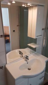 bagno con lavandino bianco e specchio di Hotel Deutsches Haus Francop ad Amburgo