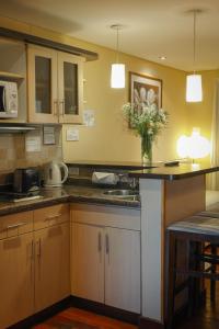 a kitchen with a counter with a vase of flowers at Hotel Ankara Suites in Salta