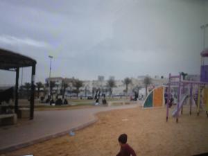 a man walking in a park with a playground at Al Makan Al Mosafer 116 Hotel by Al Azmy in Riyadh