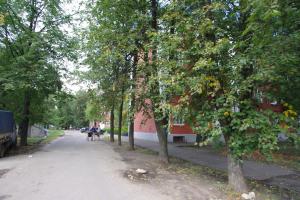 a tree lined street in front of a building at Апартаменты Бутусовские in Yaroslavl