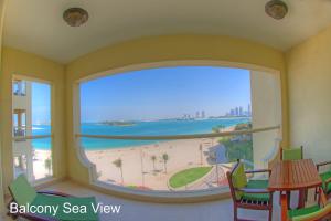 Habitación con ventana grande con vistas a la playa. en Royal Club By RVHR, Palm Jumeirah, en Dubái