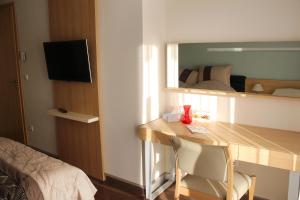 a room with a desk and a bedroom with a bed at Velence Resort Apartman in Velence