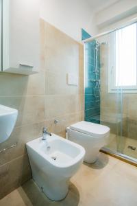een badkamer met een toilet en een wastafel bij Villa Viola in Torre Lapillo
