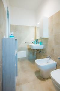 een badkamer met een wastafel, een toilet en een wastafel bij Villa Viola in Torre Lapillo