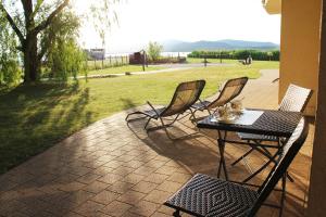 a patio with three chairs and a table with at Velence Resort Apartman in Velence