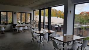 Zimmer mit Tischen, Stühlen und Fenstern in der Unterkunft Sport Pension Cibulka in Prag