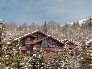 a log cabin in the snow with trees at Residence Les Fermes de Meribel - maeva Home in Méribel