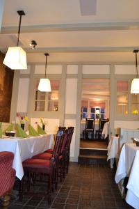 een eetkamer met tafels, stoelen en verlichting bij Hotel Zum Roten Tore in Lüneburg