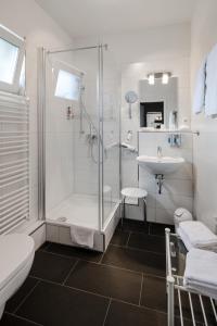 ein Bad mit einer Dusche und einem Waschbecken in der Unterkunft Hotel Zum Roten Tore in Lüneburg