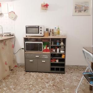 un forno a microonde seduto sopra un bancone di Casa Eleonora a Monopoli