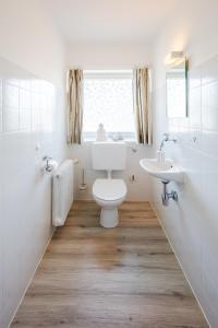 a bathroom with a toilet and a sink at Karwendellounge in Krün