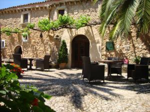 ブゲルにあるAgroturisme Son Ponsの中庭に椅子とテーブルを備えた石造りの建物
