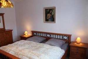 a bedroom with a bed and two night stands with lamps at Ferienwohnung-LOGA in Leer