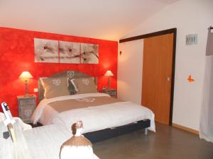 a bedroom with a large bed with red walls at Le Jardin d'Ivana in Oppède