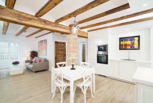 a kitchen and living room with a white table and chairs at Vivaldi Center City in Valencia