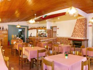 カヴァッリーノ・トレポルティにあるLocanda da Scarpaのテーブルと椅子、暖炉のあるレストラン