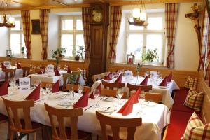 キルヒツァルテンにあるLandgasthof Bärenのテーブルと椅子と赤いナプキンを用意したレストラン