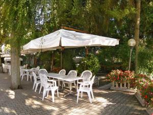 a white table and chairs under a white umbrella at Locanda da Scarpa in Cavallino-Treporti