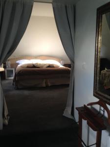 - une chambre avec un lit et un miroir dans l'établissement Château du Romerel - Baie de Somme, à Saint-Valery-sur-Somme