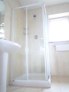 a shower with a glass door in a bathroom at Tralee Holiday Homes in Tralee