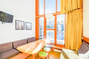 a living room with a couch and a table at Résidences quartier Charmettoger - maeva Home in Arc 1800