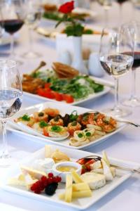 a table with three plates of food and glasses of wine at Hotel Holiday Park in Warsaw