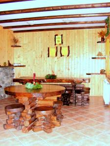 a room with wooden tables and benches and a clock at Rustic House in Stana de Vale