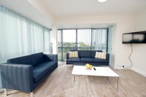 a living room with two blue couches and a table at University Hall Apartments - UCC Summer Beds in Cork