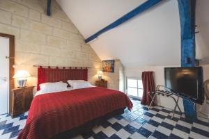 una camera con un grande letto e una TV di Logis Demeure de la Vignole a Turquant