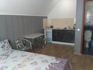 a bedroom with a bed and a table and a kitchen at Orianna in Kropyvnytskyi