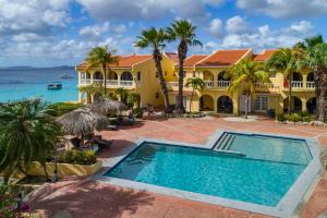 a house with a swimming pool in front of the ocean at Buddy Dive Resort in Kralendijk