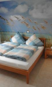 um quarto com uma cama com um quadro na parede em Ferienhaus Westwind em Rhauderfehn